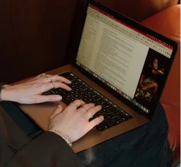 Close-up of hands typing on a laptop